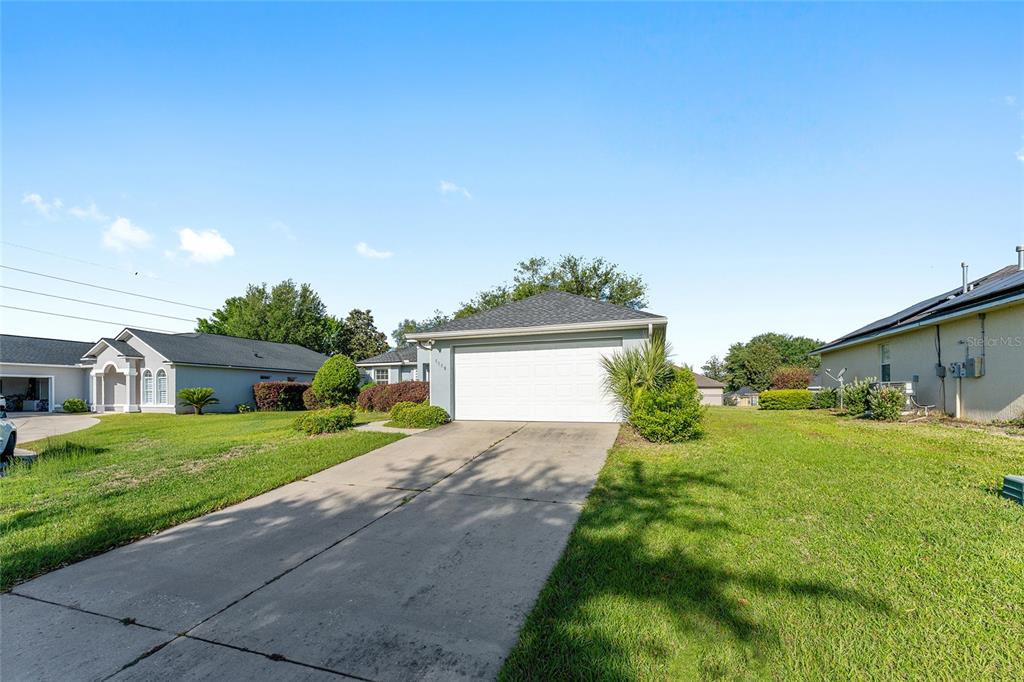 A single-story house with a white garage door and a concrete driveway — 6550 SW 50TH COURT, OCALA, FL