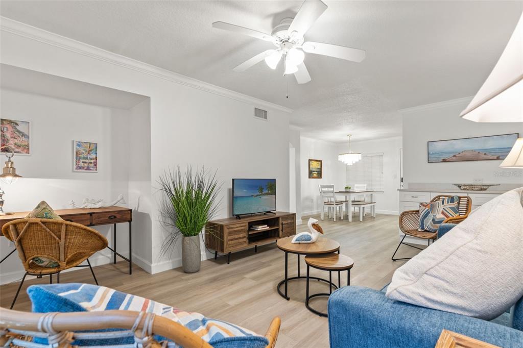 A bright living room features light wood flooring, a ceiling fan, and coastal-style furniture — 19417 GULF BOULEVARD UNIT C106, INDIAN ROCKS BEACH, FL