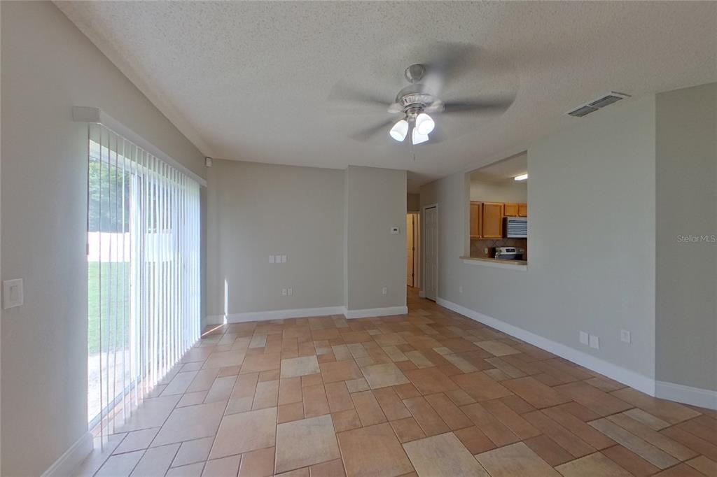 A living area features tile flooring, a ceiling fan, and a sliding glass door — 1141 DONCASTER COURT, KISSIMMEE, FL