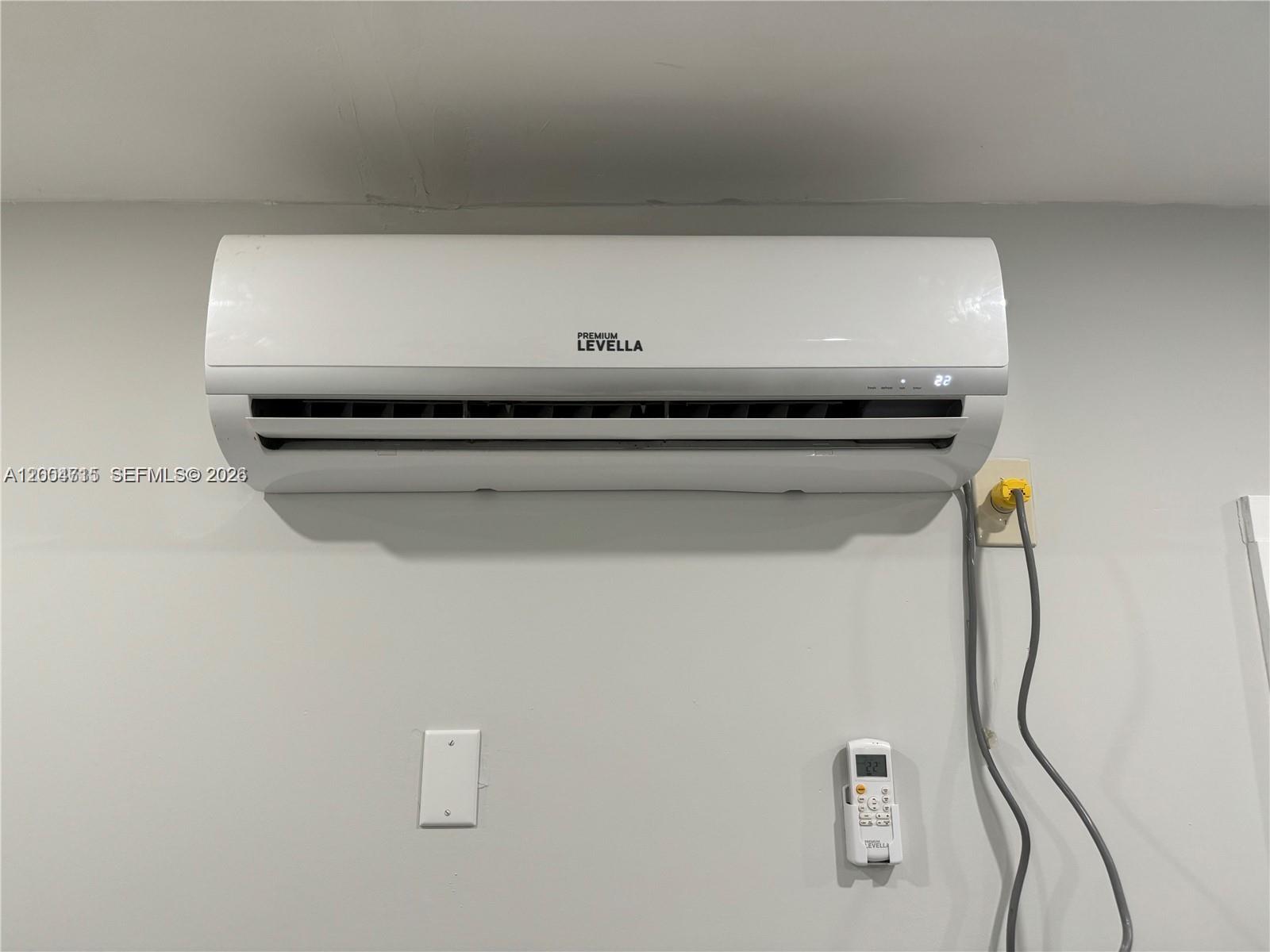 A wall-mounted Premium Levella air conditioning unit is installed above a remote control — 6335 N Miami Ave # 3, Miami FL 33150, MIAMI, FL