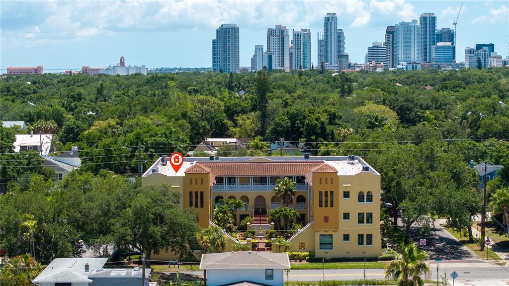 A high-angle view of a landing with tile flooring, hardwood stairs, and tall windows — 210 22ND AVENUE NE UNIT 6, ST PETERSBURG, FL