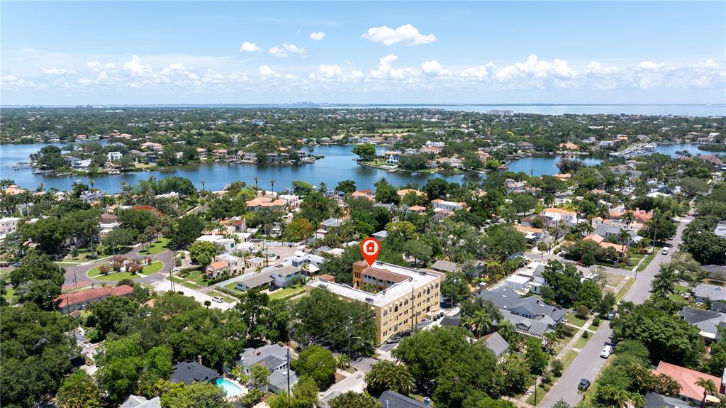 A covered balcony features terracotta tile flooring, wicker furniture, and a white wooden railing — 210 22ND AVENUE NE UNIT 6, ST PETERSBURG, FL