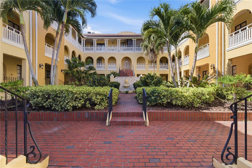 A bedroom features hardwood floors, a ceiling fan, stained glass windows, and a metal bed — 210 22ND AVENUE NE UNIT 6, ST PETERSBURG, FL