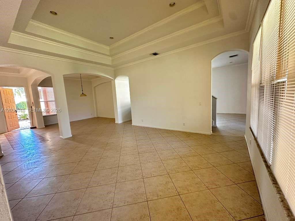 An open-concept living area features a tray ceiling, arched doorways, and light-colored tile flooring — 1831 Mariners Ln, Weston FL 33327, WESTON, FL