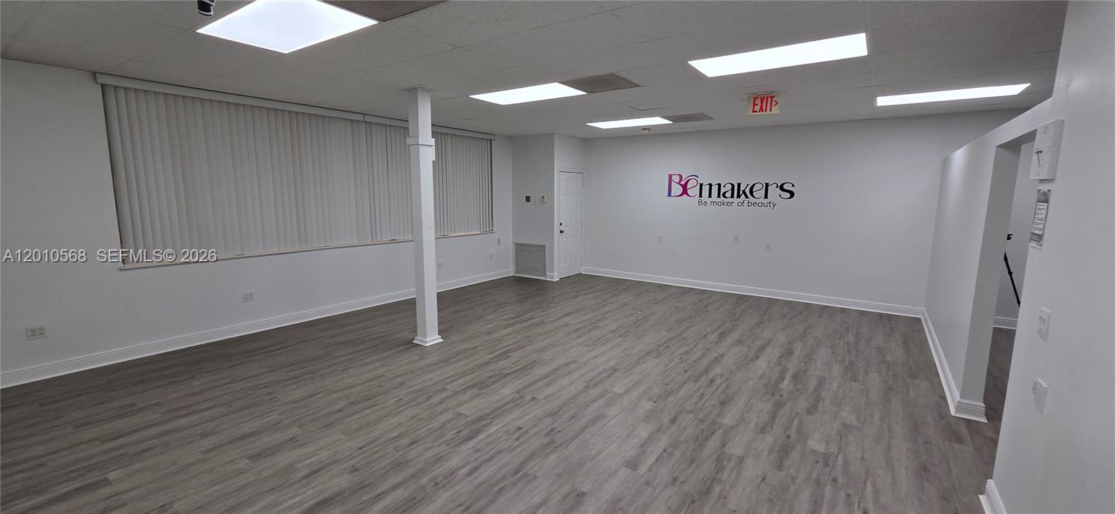 An empty commercial office space with gray wood-look flooring, white walls, and recessed lighting — 4503 NW 103rd Ave # 104, Sunrise FL 33351, SUNRISE, FL