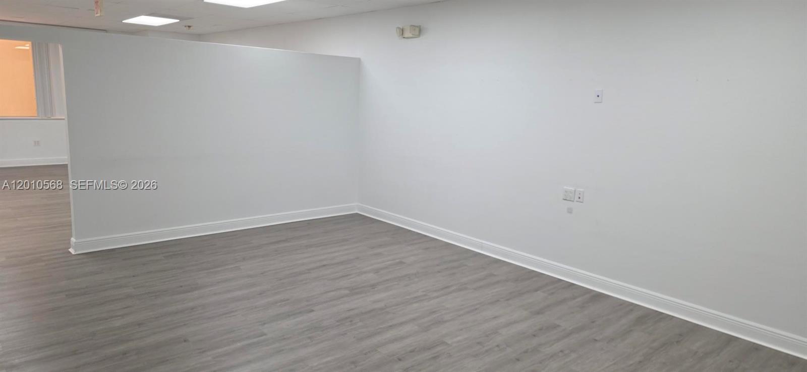 An empty office space features white walls, gray wood-look flooring, and a drop ceiling — 4503 NW 103rd Ave # 104, Sunrise FL 33351, SUNRISE, FL