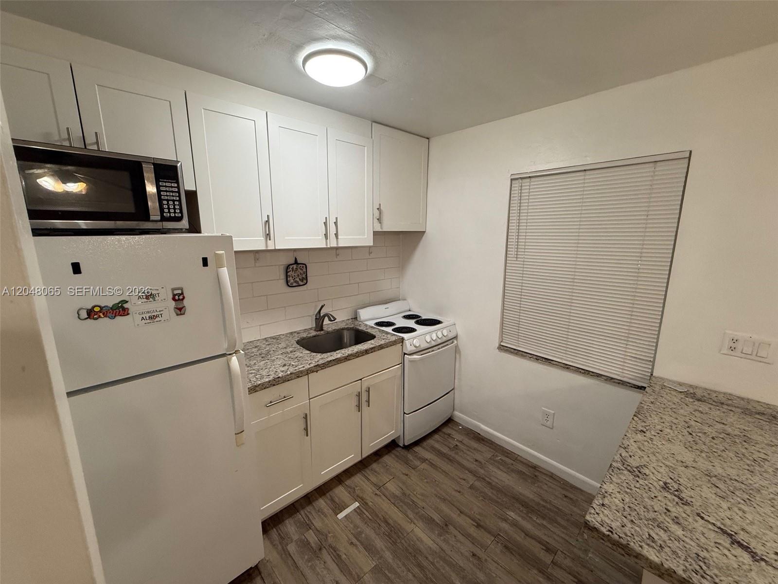 A single-story house with beige siding, a concrete driveway, and a carport — 34 SW 5th St # 2, Hallandale Beach FL 33009, HALLANDALE BEACH, FL