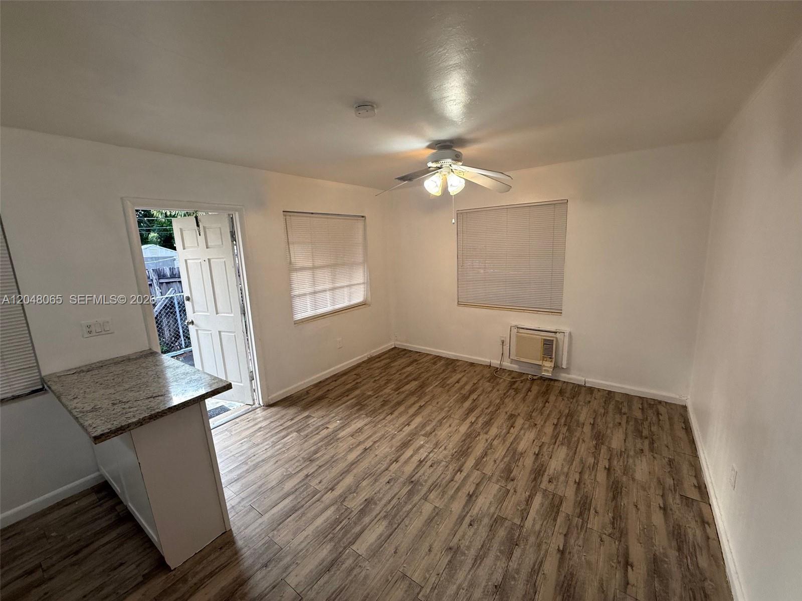 A bathroom features a marble-tiled walk-in shower, a white vanity, and a toilet — 34 SW 5th St # 2, Hallandale Beach FL 33009, HALLANDALE BEACH, FL