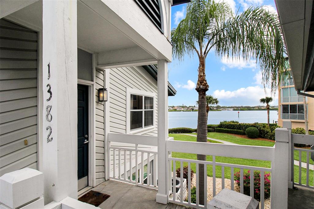 A covered balcony entrance features a house number, white railings, and a view of water — 1382 SIESTA BAYSIDE DRIVE UNIT 1382-C, SARASOTA, FL
