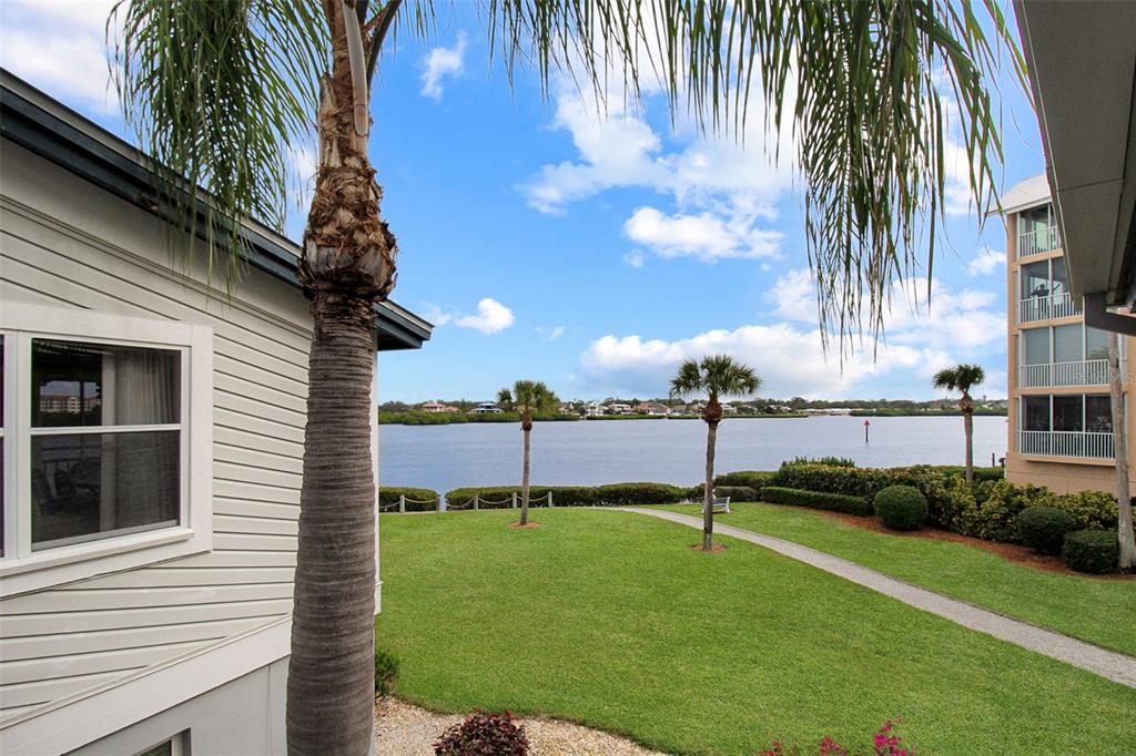 A view of a grassy lawn, palm trees, and a body of water from a balcony — 1382 SIESTA BAYSIDE DRIVE UNIT 1382-C, SARASOTA, FL