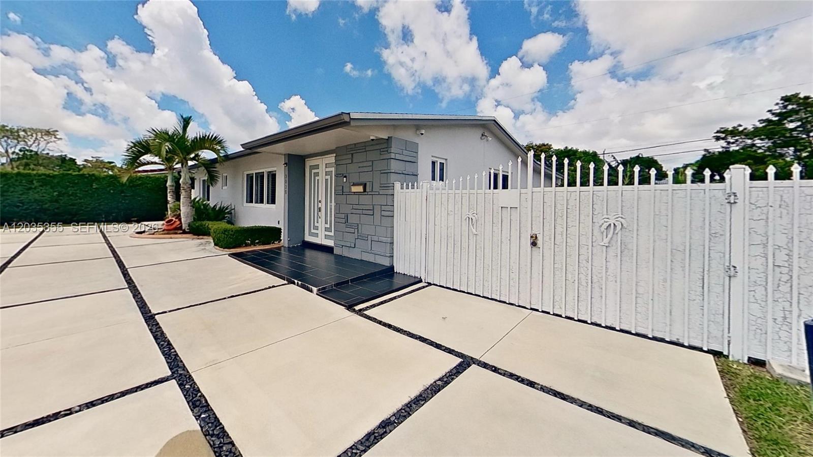 A single-story house features a gray stone accent wall, white double doors, and a paved driveway — 3030 SW 96th Ave, Miami FL 33165, MIAMI, FL