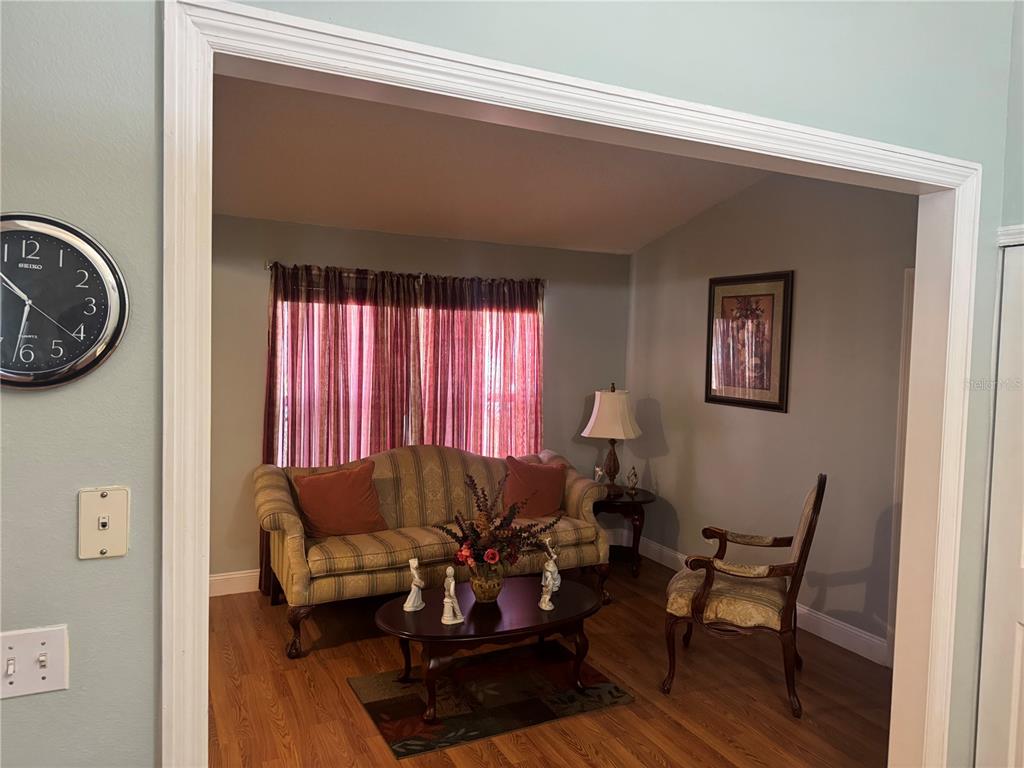 A living room features a striped sofa, a wooden coffee table, and a wooden chair — 1112 ROAN COURT, KISSIMMEE, FL