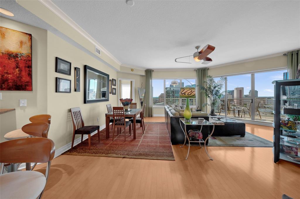 An open-concept living and dining area features hardwood floors, floor-to-ceiling windows, and city views — 449 S 12TH STREET UNIT 2205, TAMPA, FL