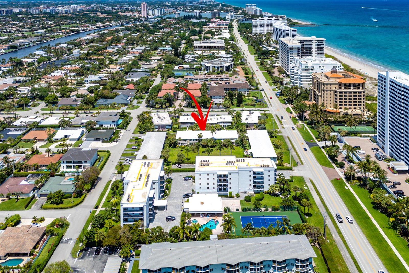 An aerial view shows a multi-story apartment complex with a pool and tennis court — 930 Osceola Drive # 9, Boca Raton FL 33432, BOCA RATON, FL