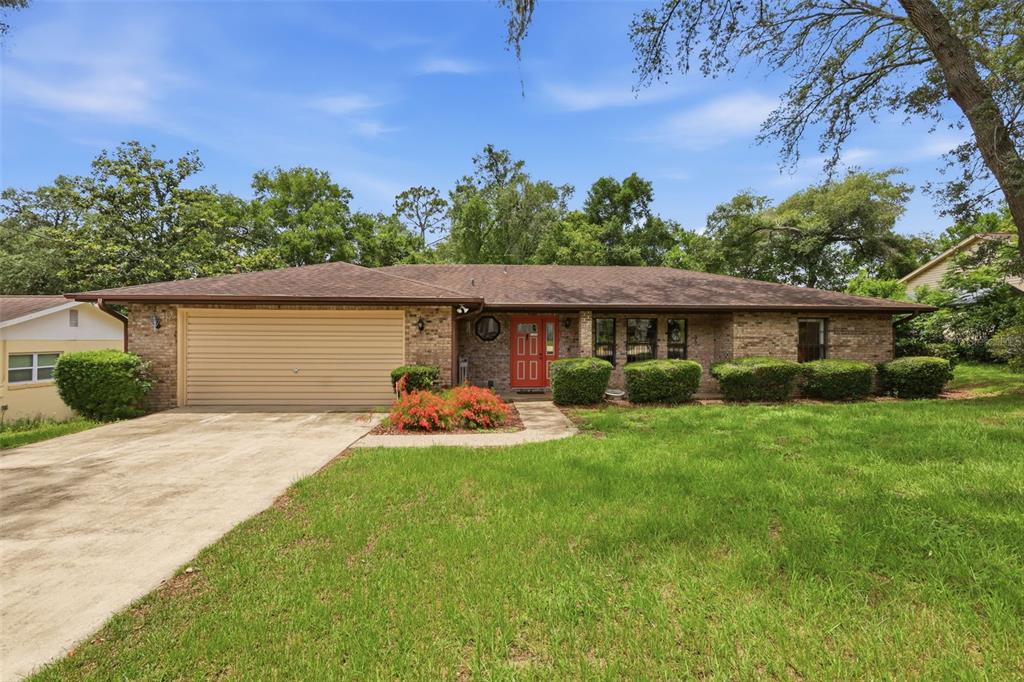 A single-story brick house with a tan garage door and a red front door — 2360 DARTMOUTH ROAD, DELAND, FL