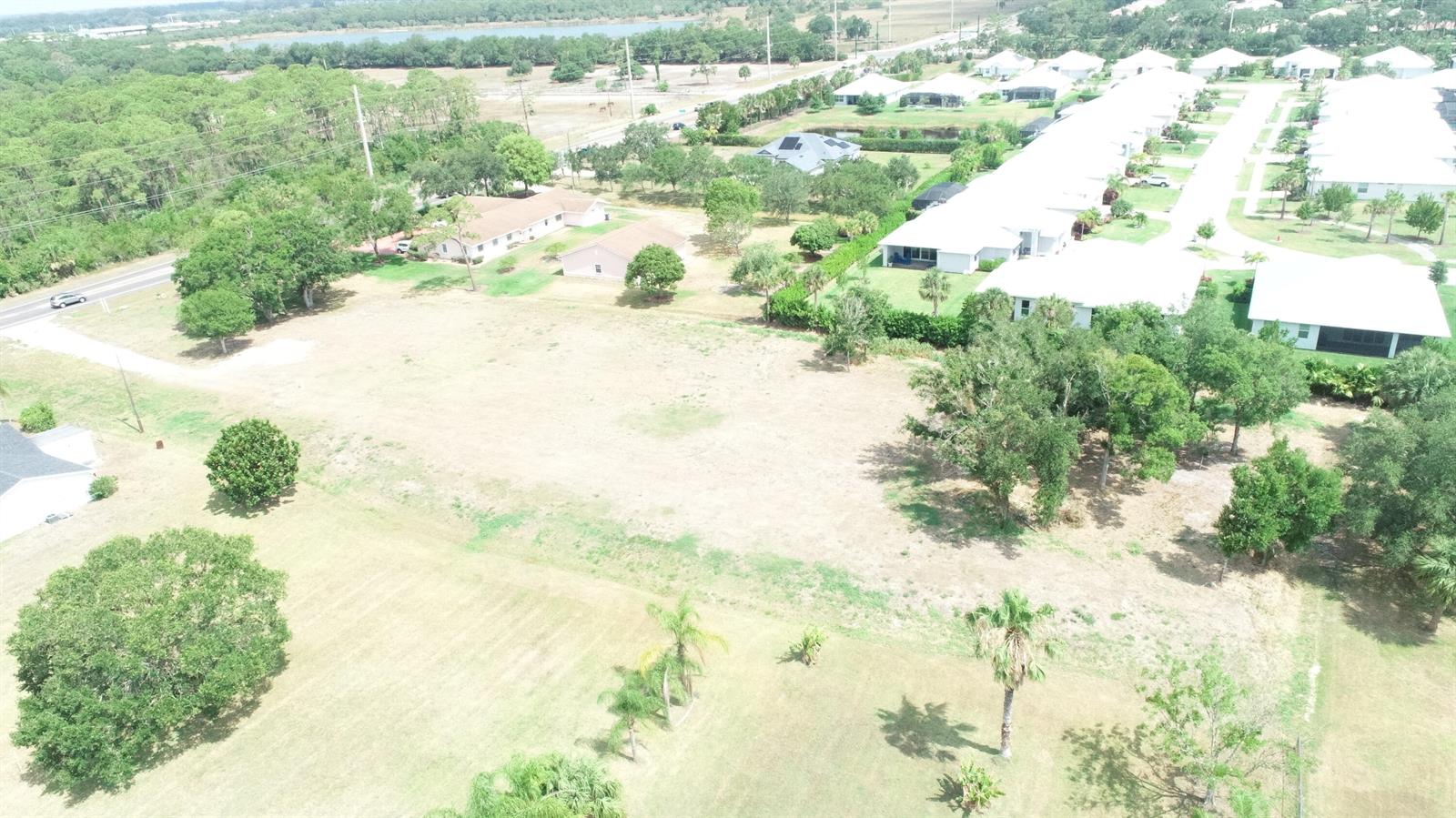 An aerial view shows a large, vacant grassy lot adjacent to a residential neighborhood — 4716 58th Avenue, Vero Beach FL 32967, VERO BEACH, FL