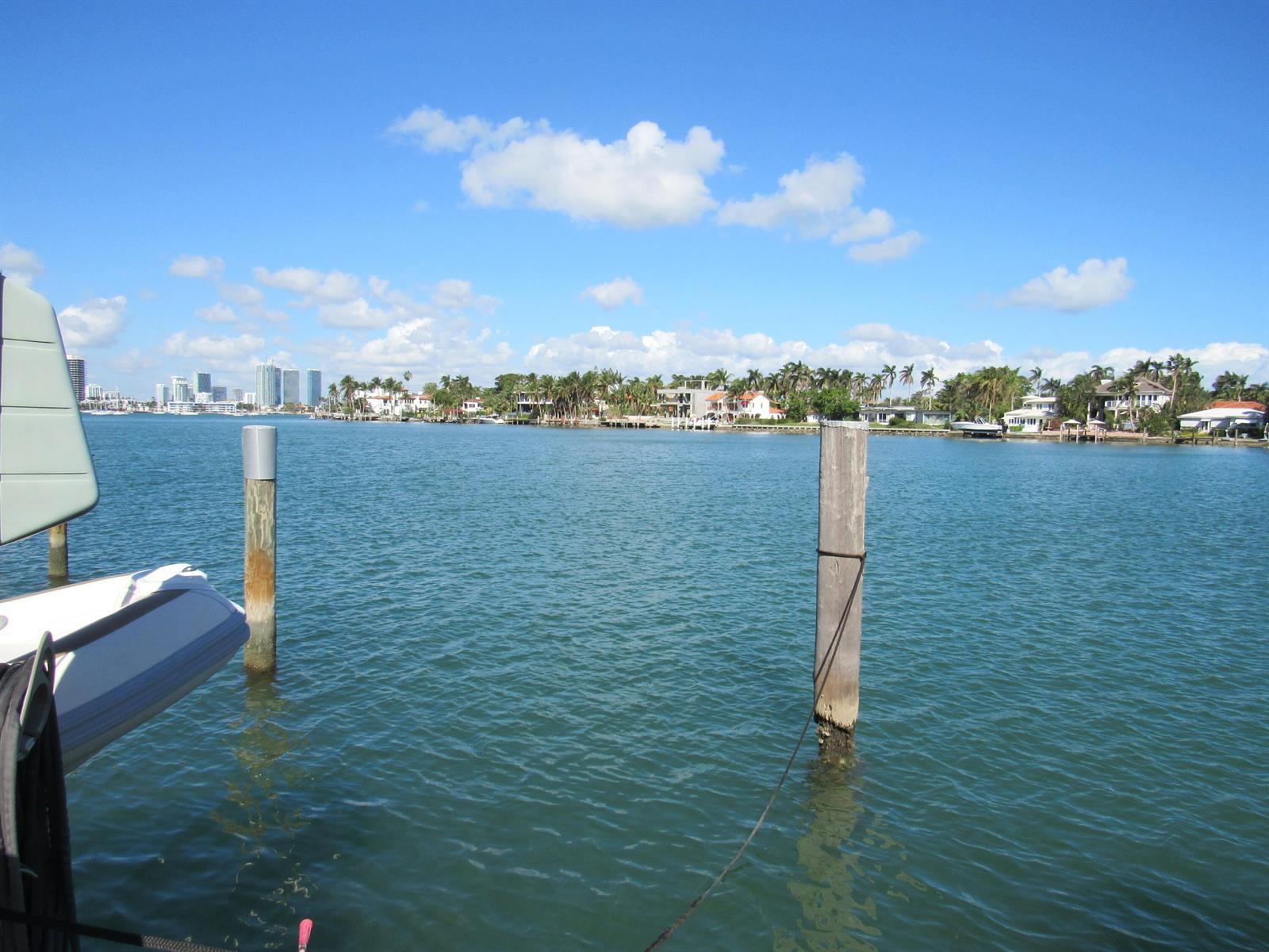 A view of a calm waterway with wooden pilings, distant houses, and a city skyline — 185 Palm Avenue, Miami Beach FL 33139, MIAMI BEACH, FL