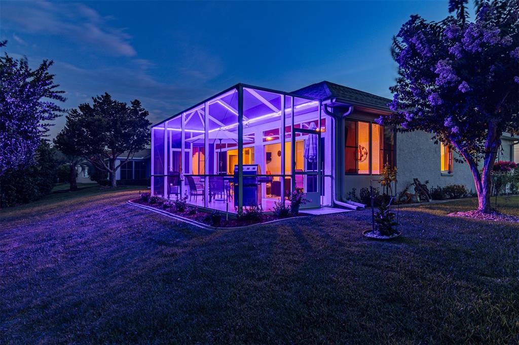 A screened-in patio with purple accent lighting is attached to the rear of a house — 2291 NW 59TH TERRACE, OCALA, FL