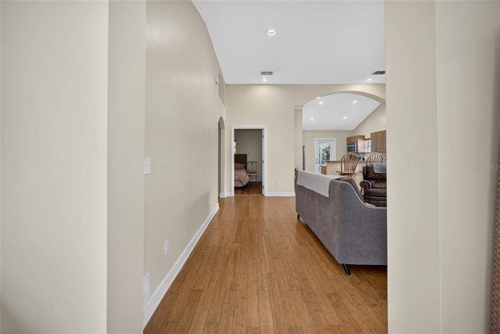 A hallway with hardwood floors leads to a living area and a bedroom doorway — 125 PAGE STREET, ORLANDO, FL