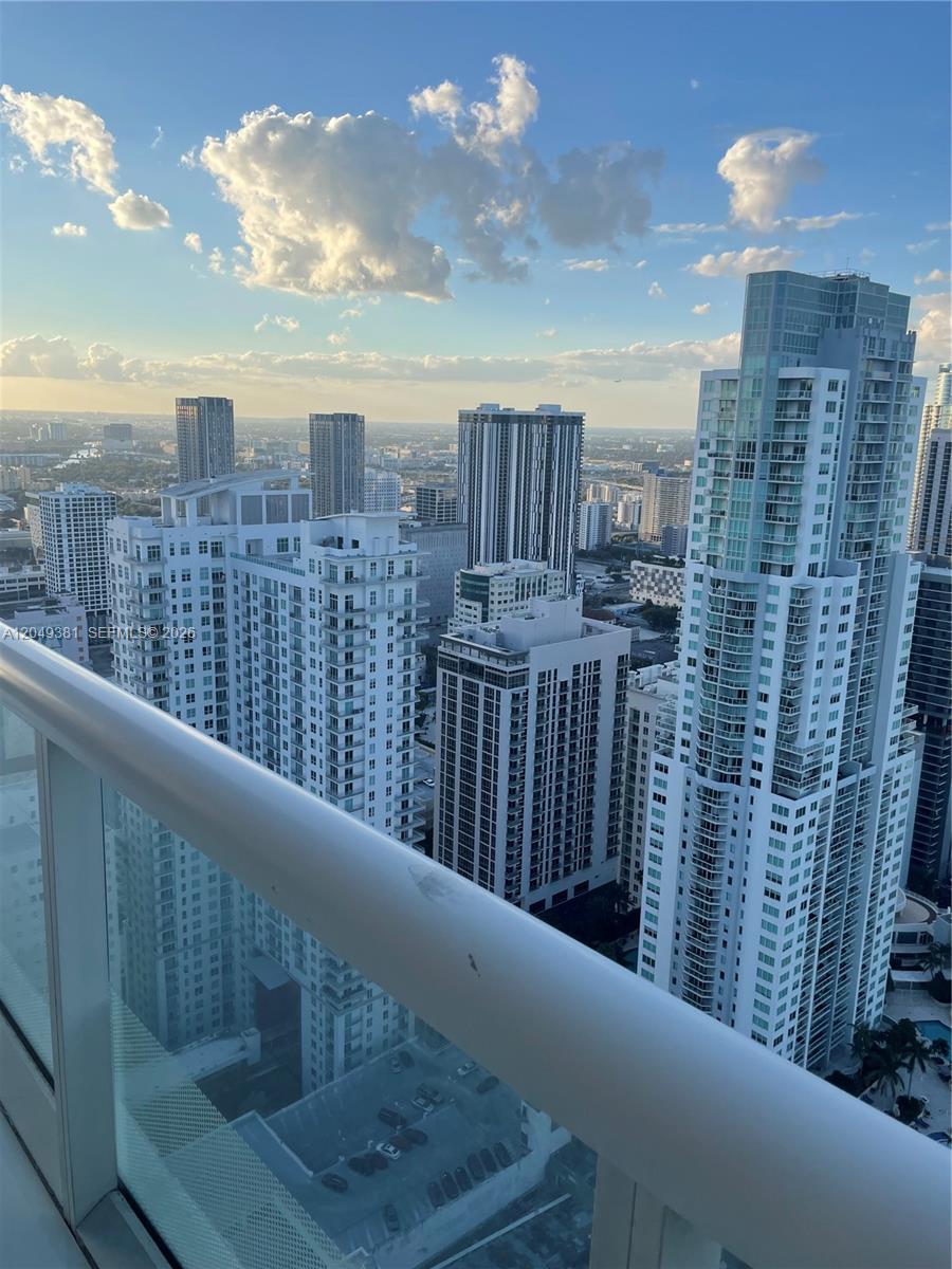 A high-angle view of a city skyline featuring multiple modern residential skyscrapers and balconies — 50 Biscayne Blvd # 5001, Miami FL 33132, MIAMI, FL