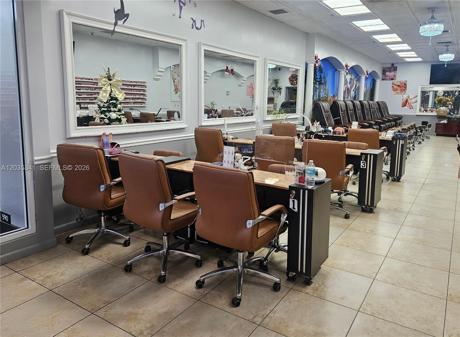 A nail salon features rows of brown leather chairs at workstations with mirrors and tile flooring — 1455 NW 107, Doral FL 33172, DORAL, FL