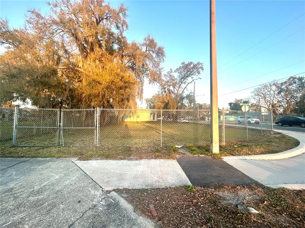 A fenced vacant lot with large trees sits at a street corner — 2035 S RIO GRANDE AVENUE, ORLANDO, FL