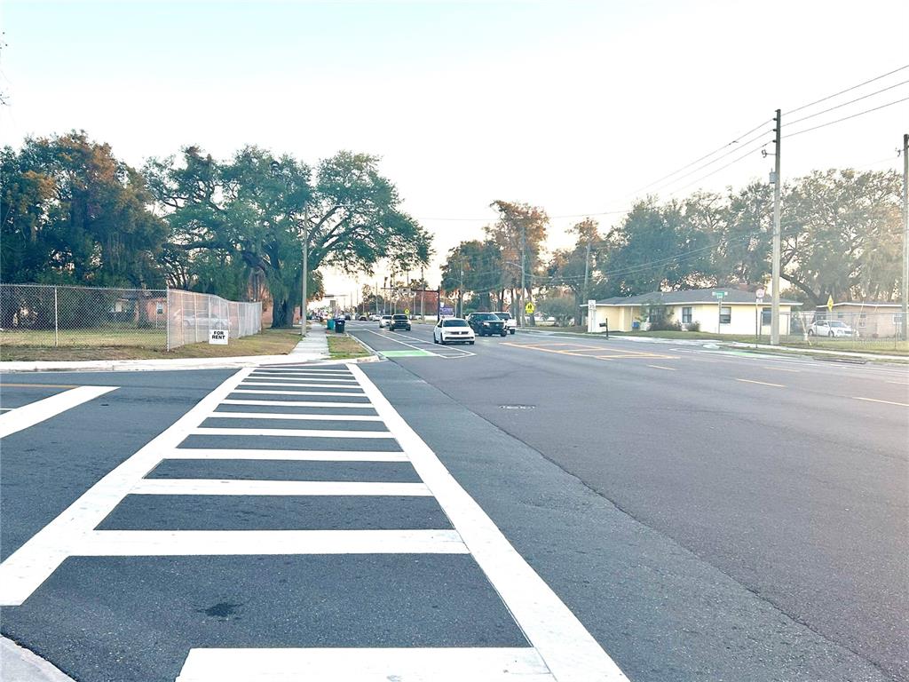 A street view shows a crosswalk in the foreground with cars driving on the road — 2035 S RIO GRANDE AVENUE, ORLANDO, FL