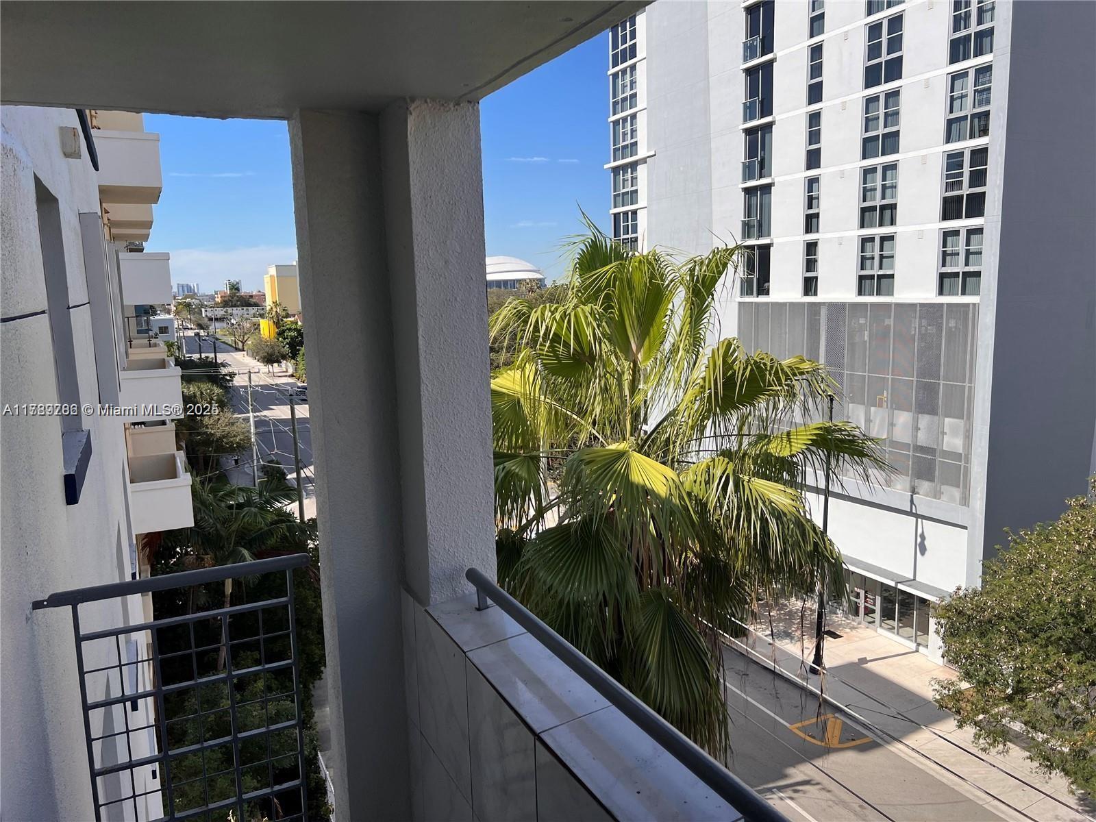 An outdoor apartment building hallway features white walls, gray flooring, and metal railings — 546 SW 1st St # 611, Miami FL 33130, MIAMI, FL