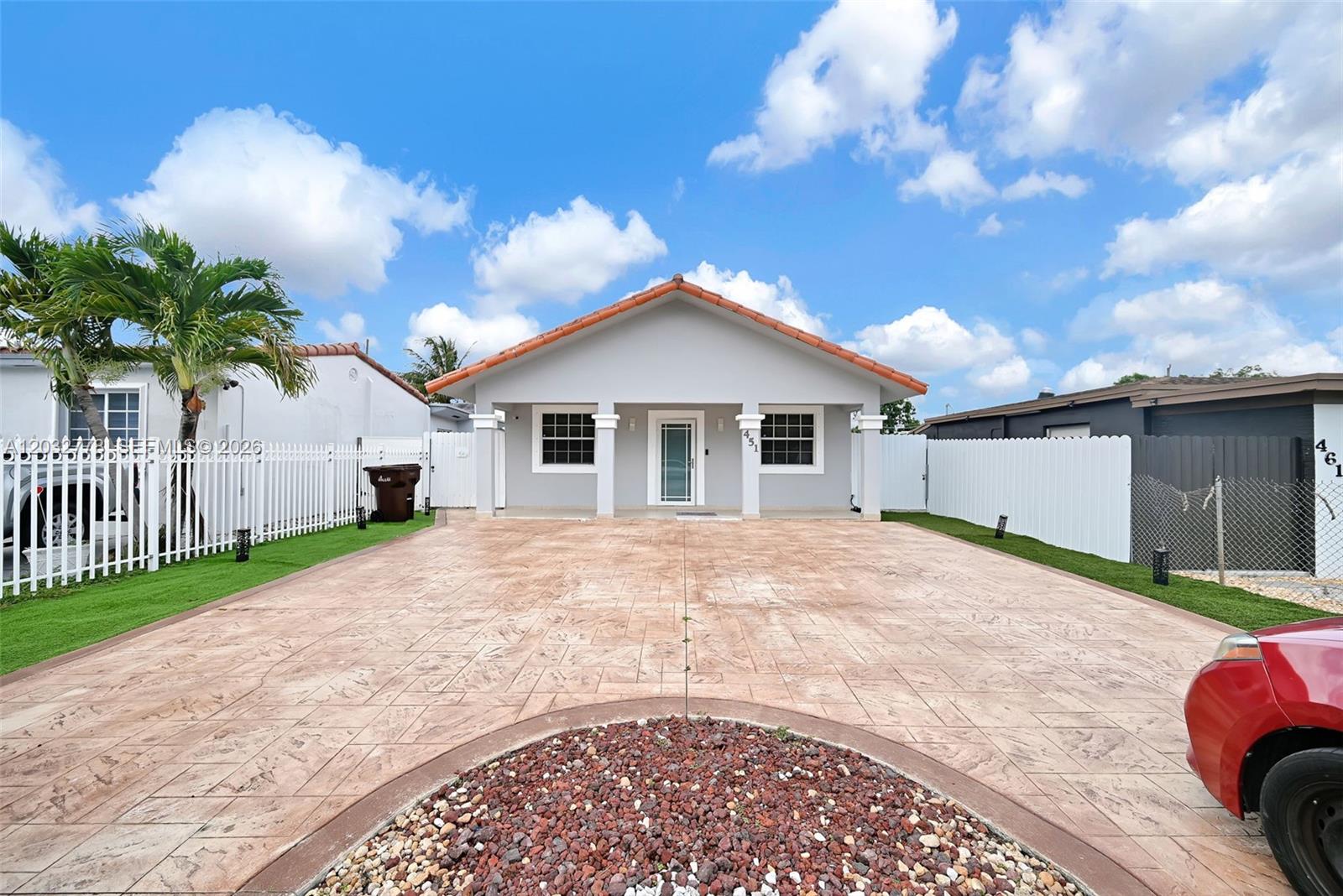 The exterior of a single-story house features a stamped concrete driveway and a tile roof — 451 E 37th St, Hialeah FL 33013, HIALEAH, FL