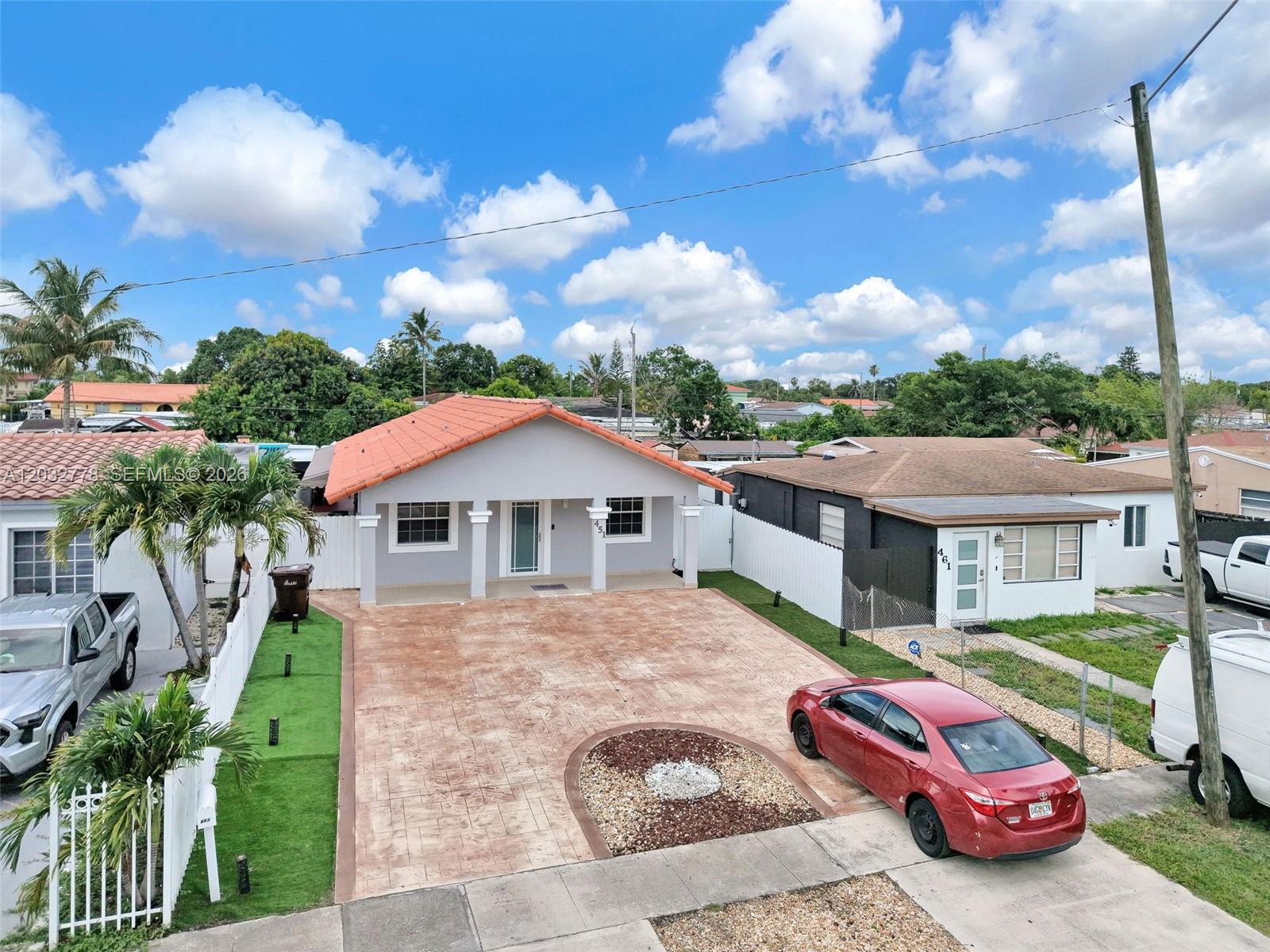 An elevated view shows a gray house with a red tile roof and a paved driveway — 451 E 37th St, Hialeah FL 33013, HIALEAH, FL