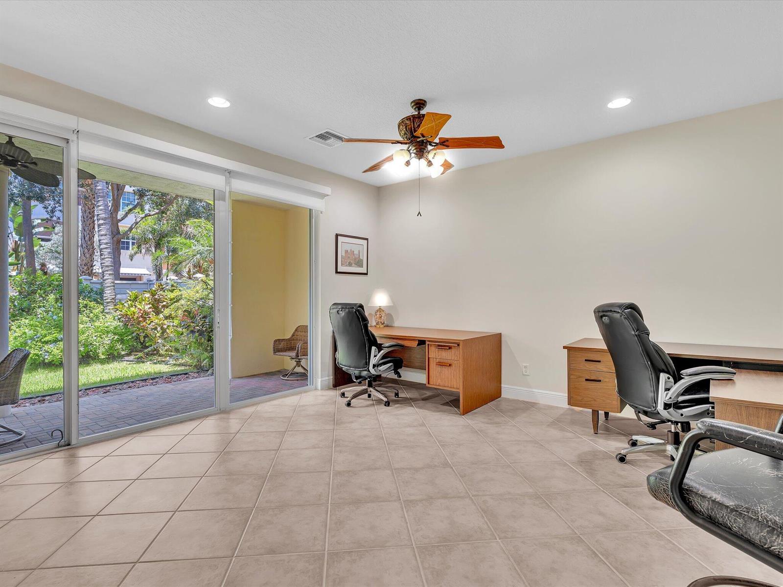 A home office with tile floors, two desks, black chairs, and a sliding glass door — 5575 NE Trieste Way, Boca Raton FL 33487, BOCA RATON, FL