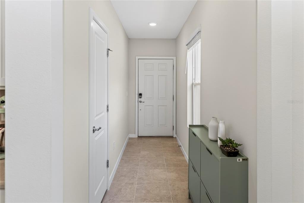 A narrow entryway features tile flooring, a white front door, and a green storage cabinet — 3082 GREEN PARK DRIVE, DELAND, FL
