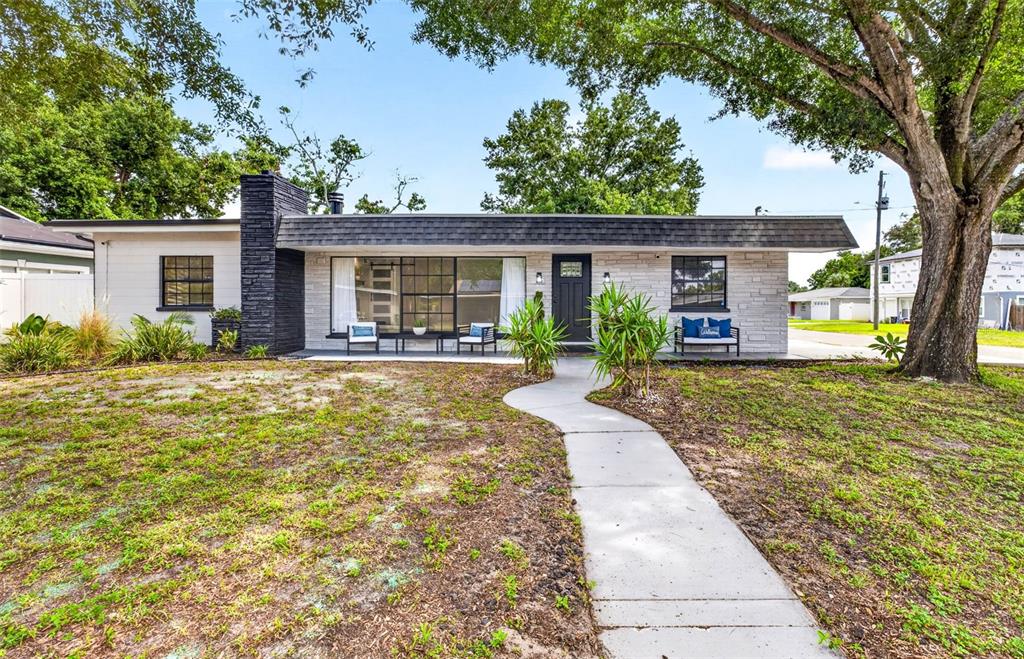A single-story house with a white stone facade, black chimney, and a front walkway — 1601 E PARIS STREET, TAMPA, FL