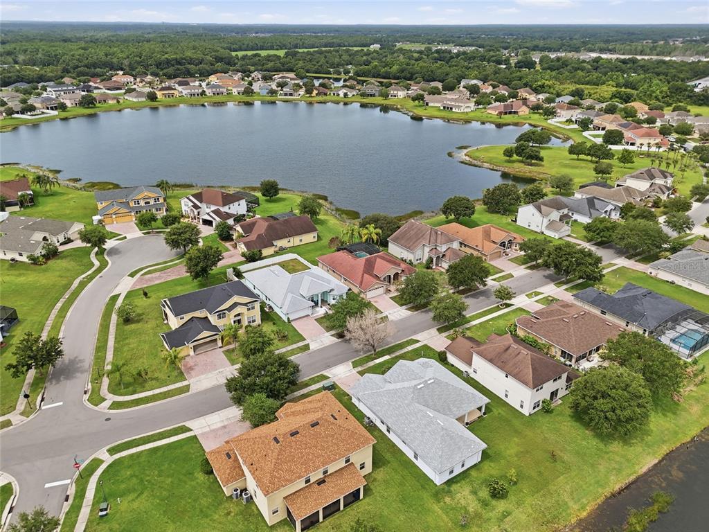 An aerial view shows suburban houses surrounding a large lake in a residential neighborhood — 2901 SWEETSPIRE CIRCLE, KISSIMMEE, FL