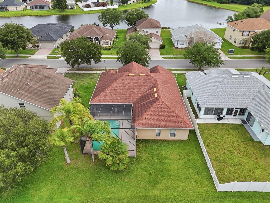 An aerial view shows a house with a red roof, a screened pool, and a yard — 2901 SWEETSPIRE CIRCLE, KISSIMMEE, FL