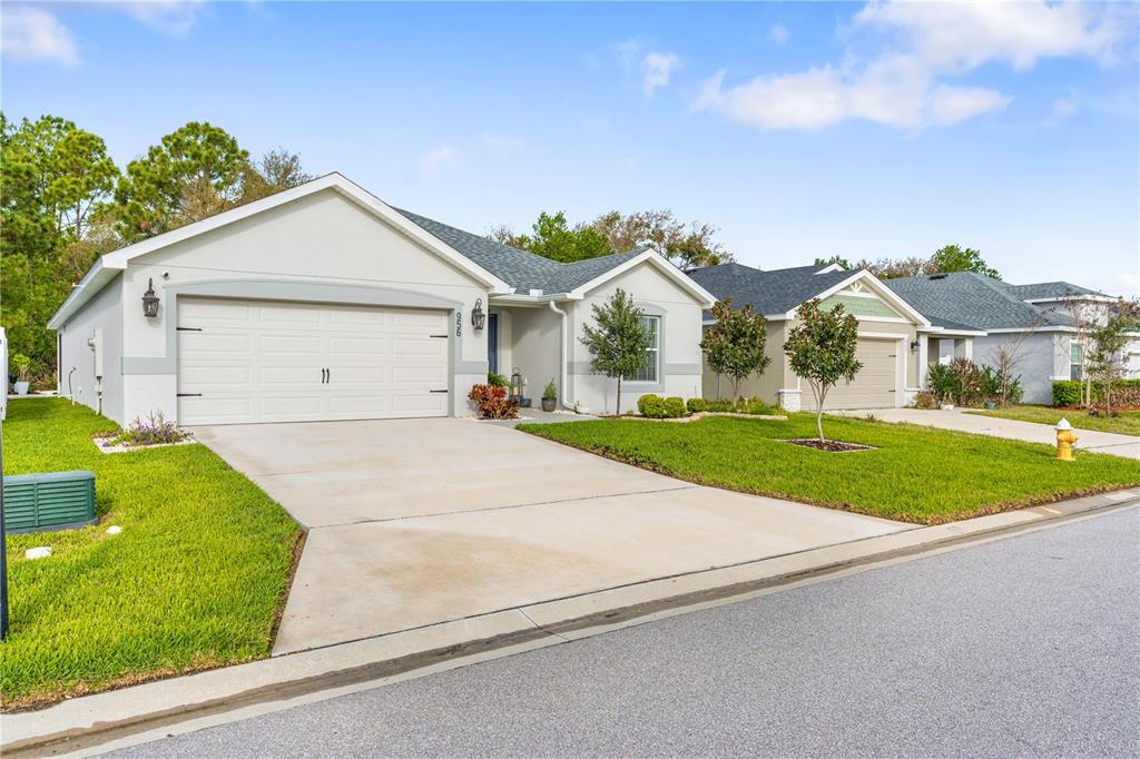 A single-story suburban house with a two-car garage and a concrete driveway — 956 ARUBA AVENUE, MULBERRY, FL