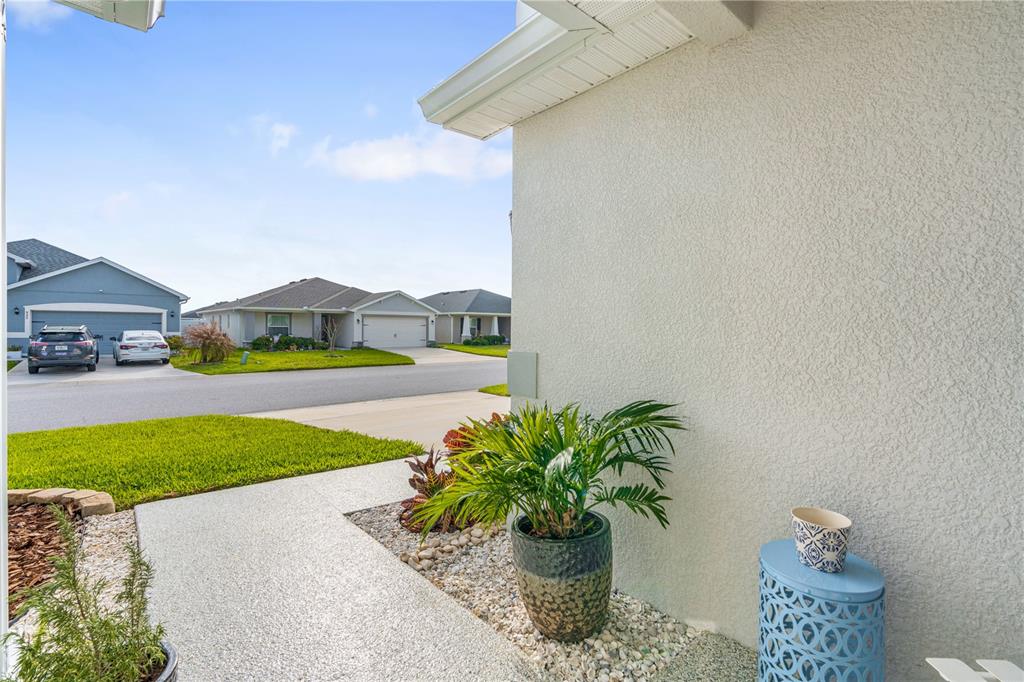 A view from a covered porch looking out toward a suburban street and neighboring houses — 956 ARUBA AVENUE, MULBERRY, FL