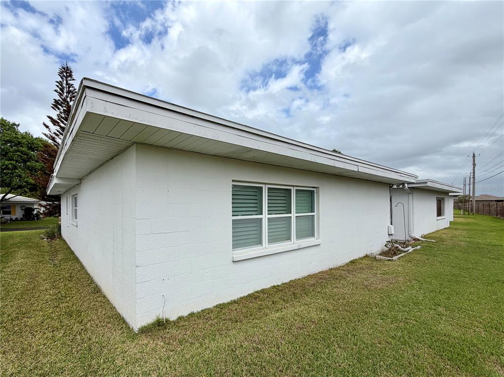 A white concrete block exterior wall of a house with a window and overhanging roof — 524 CAMEO DRIVE, LAKELAND, FL