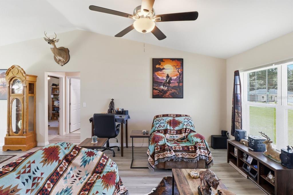 A living room features a ceiling fan, a grandfather clock, a recliner, and western-themed decor — 13730 SW 102ND STREET, DUNNELLON, FL