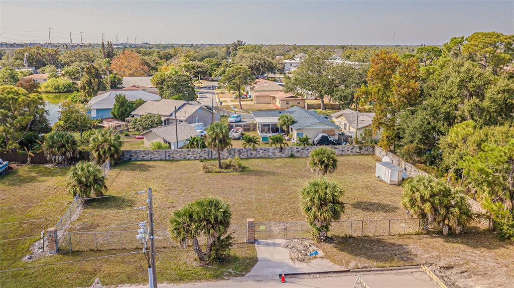 An aerial view of a vacant, fenced-in residential lot with several palm trees — 7598 90TH STREET, SEMINOLE, FL