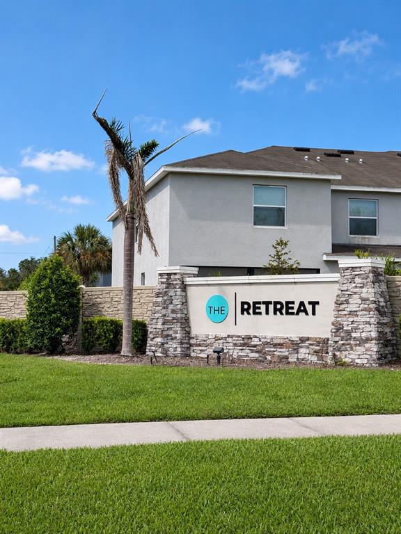 A stone-accented monument sign for The Retreat stands in front of a two-story residential building — 809 LUCENT SANDS COURT, BRANDON, FL