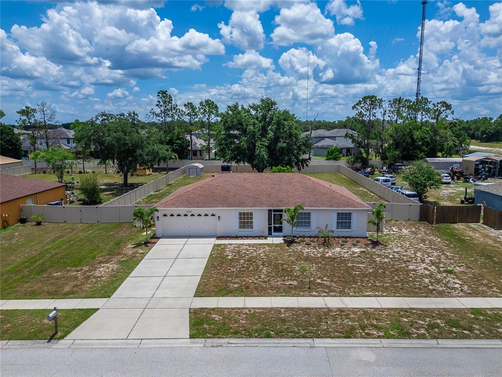 An aerial view of a single-story house with a tan roof and a concrete driveway — 12124 COLONIAL ESTATES LANE, RIVERVIEW, FL