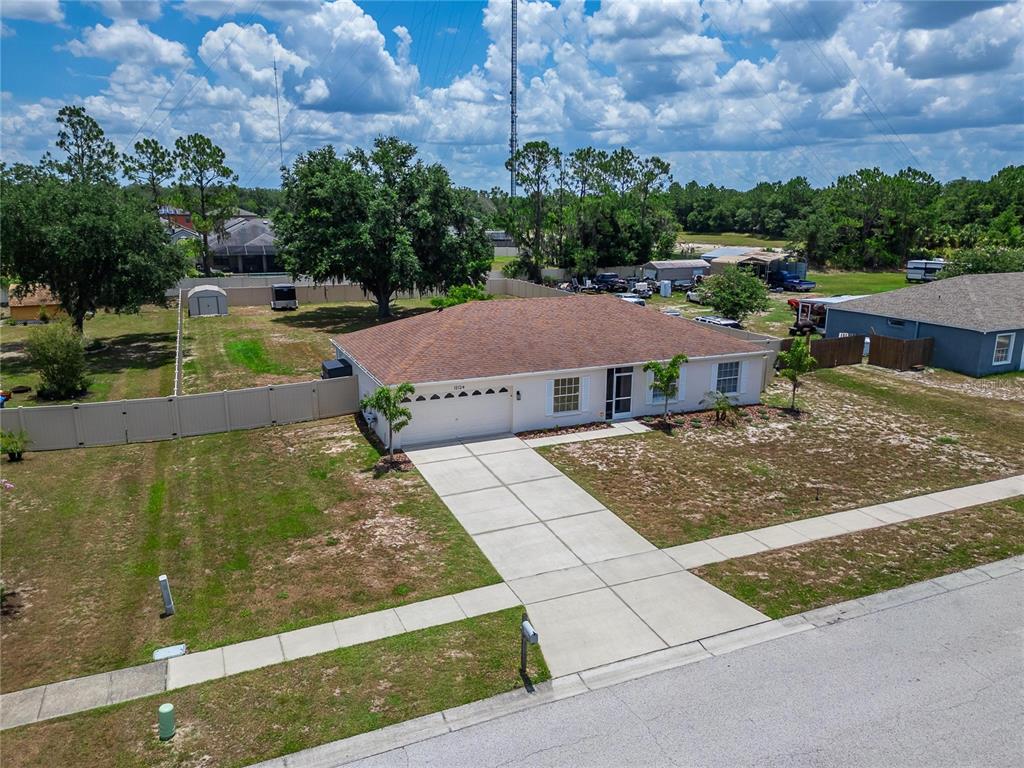 An aerial view shows a single-story house with a brown roof, white siding, and driveway — 12124 COLONIAL ESTATES LANE, RIVERVIEW, FL