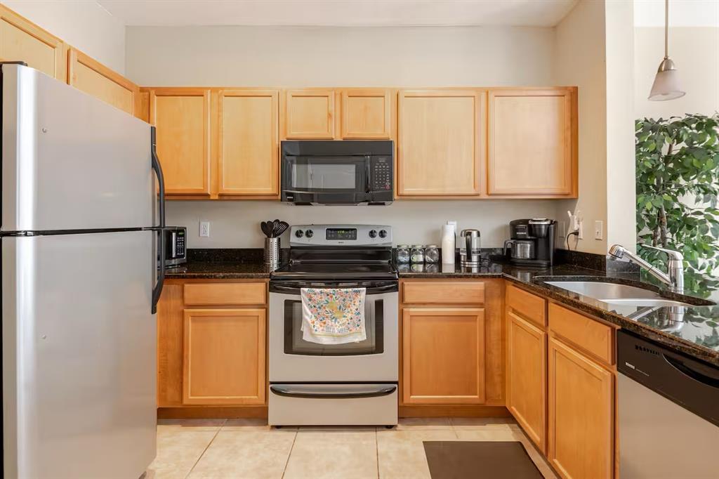 A kitchen with light wood cabinets, stainless steel appliances, and dark granite countertops — 2960 SW 35TH PLACE UNIT 65, GAINESVILLE, FL