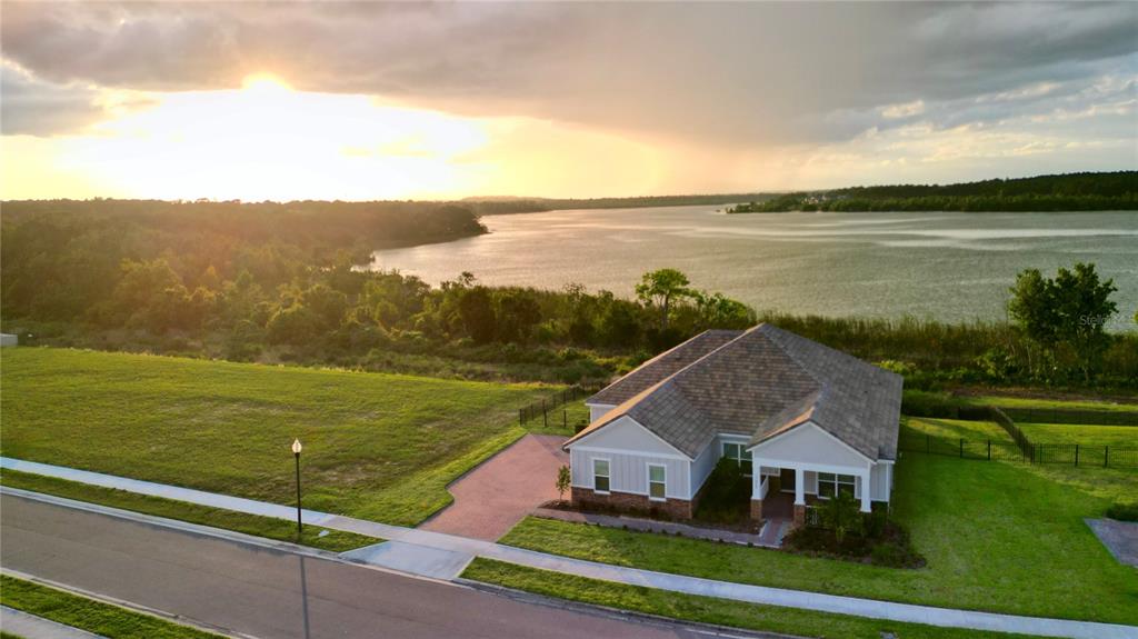 An aerial view of a single-story house with a brick driveway next to a lake — 17854 HITHER HILLS CIRCLE, WINTER GARDEN, FL
