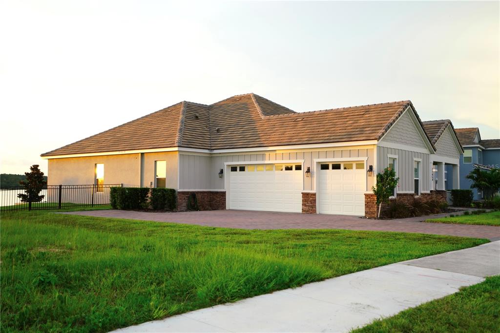 A single-story house with a two-car garage, stone accents, and a paved driveway — 17854 HITHER HILLS CIRCLE, WINTER GARDEN, FL