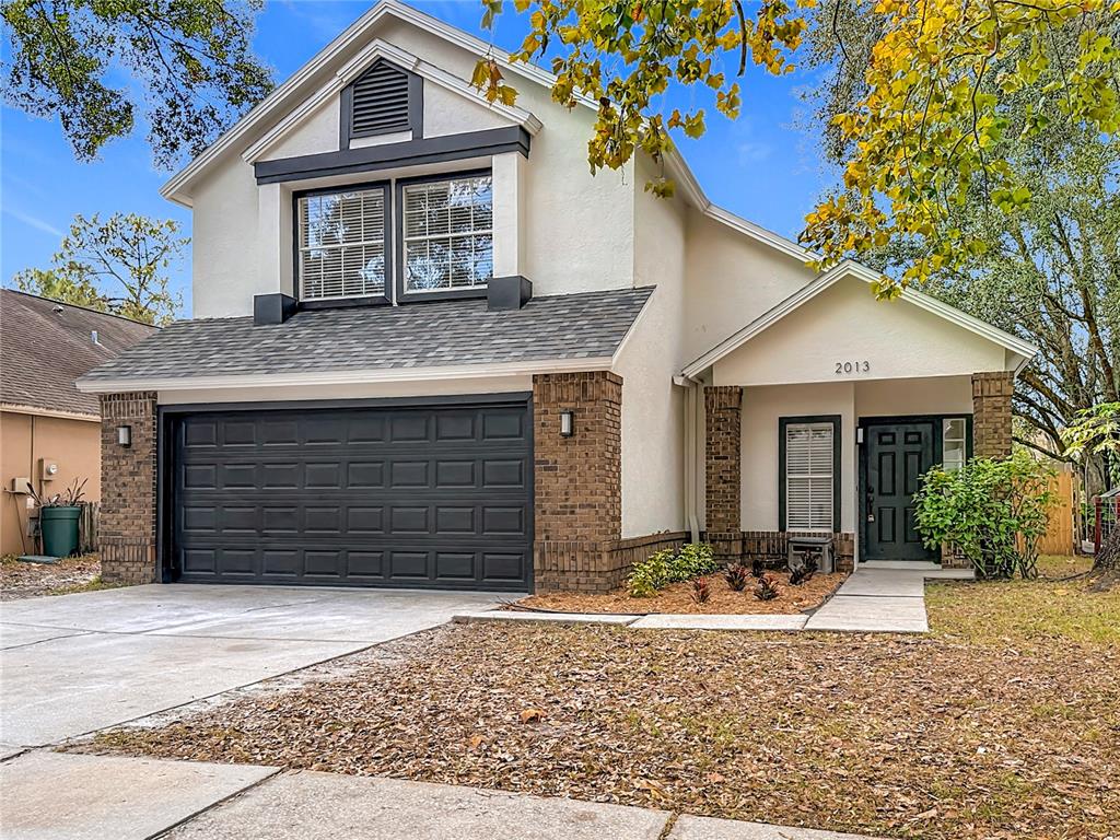 A two-story house with a two-car garage, brick accents, and a front entrance walkway — 2013 GLEN FORGE STREET, BRANDON, FL