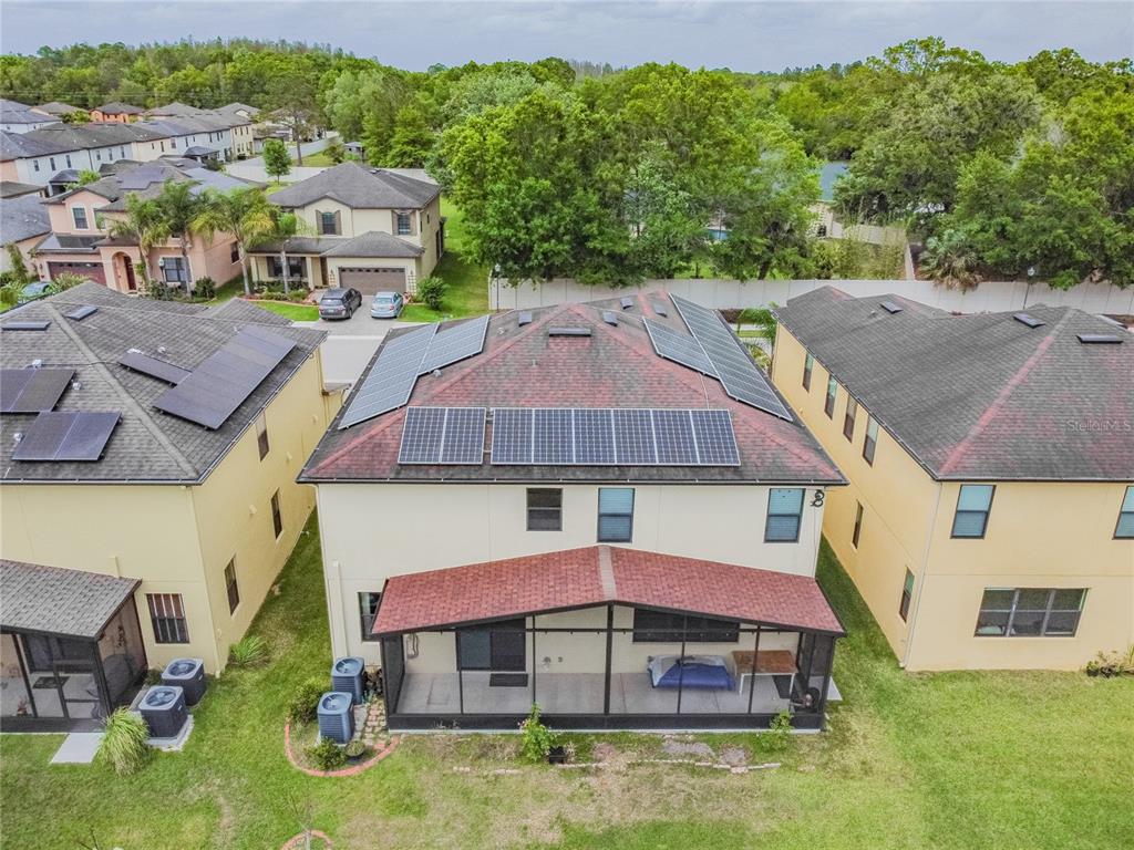 An aerial view of a two-story house with solar panels on the roof and a lanai — 11027 TAHITI ISLE LANE, TAMPA, FL
