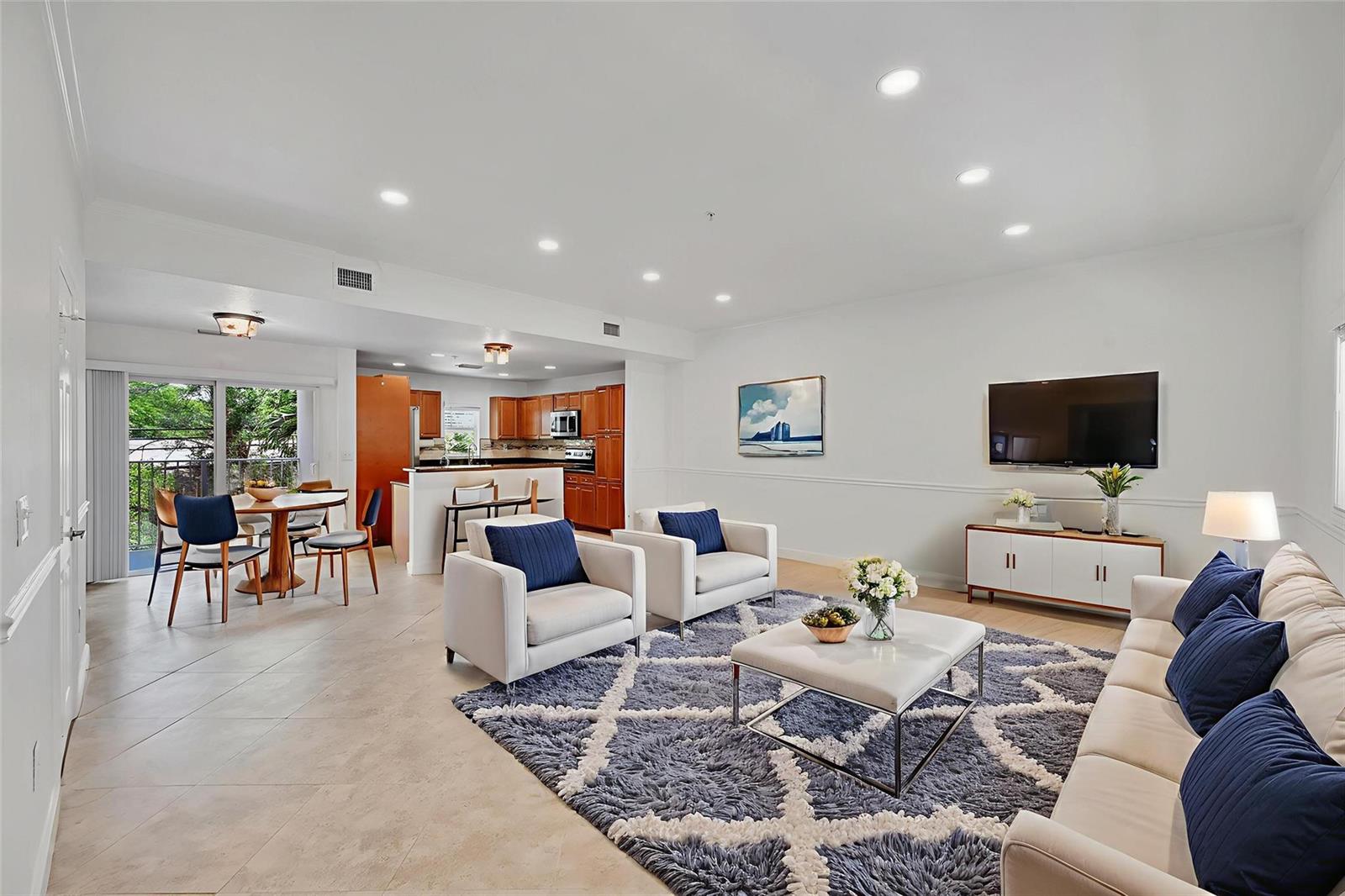 An open-concept living and dining area features tile floors, a kitchen, and blue accents — 453 NE 1st Street, Pompano Beach FL 33060, POMPANO BEACH, FL