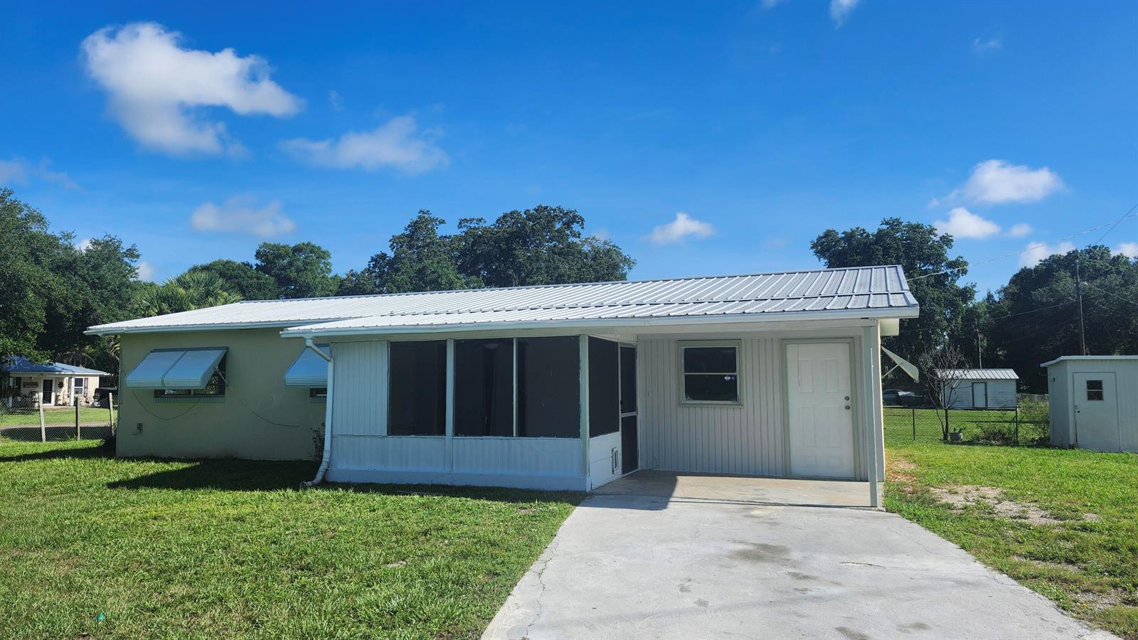 A single-story house with a metal roof, a screened porch, and a concrete driveway — 3751 NW 36th Street, Okeechobee FL 34972, OKEECHOBEE, FL